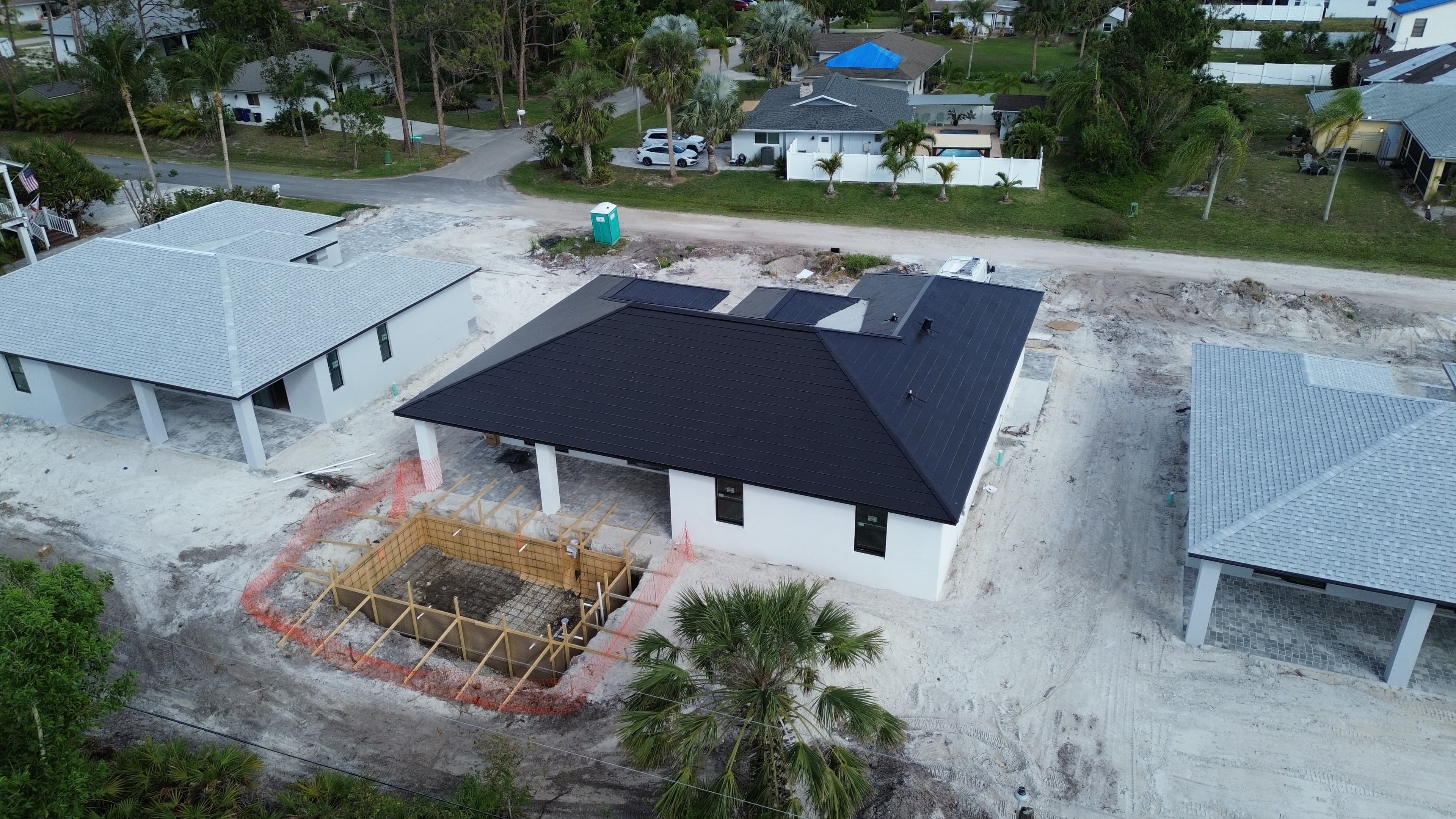 Home under construction with pool excavation
